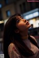 A woman with long black hair looking up at the sky.