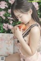 A woman in lingerie eating an apple on a couch.