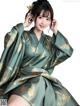 A woman in a green and gold kimono posing for a picture.