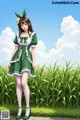 A woman in a green dress standing in a field of tall grass.