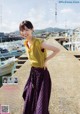 A woman standing on a dock next to a body of water.