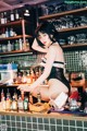 A woman in a black lingerie sitting at a bar.