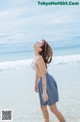 A woman standing in the water at the beach.