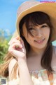 A woman wearing a straw hat poses for a picture.