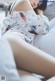 A woman laying on a bed in a white pajamas.