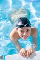 A woman in a swimming cap and goggles in a pool.