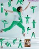 A woman in a green outfit is dancing in the air.