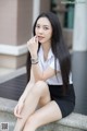 A woman sitting on the steps of a building talking on a cell phone.