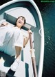 A woman in a white dress is sitting in a boat.